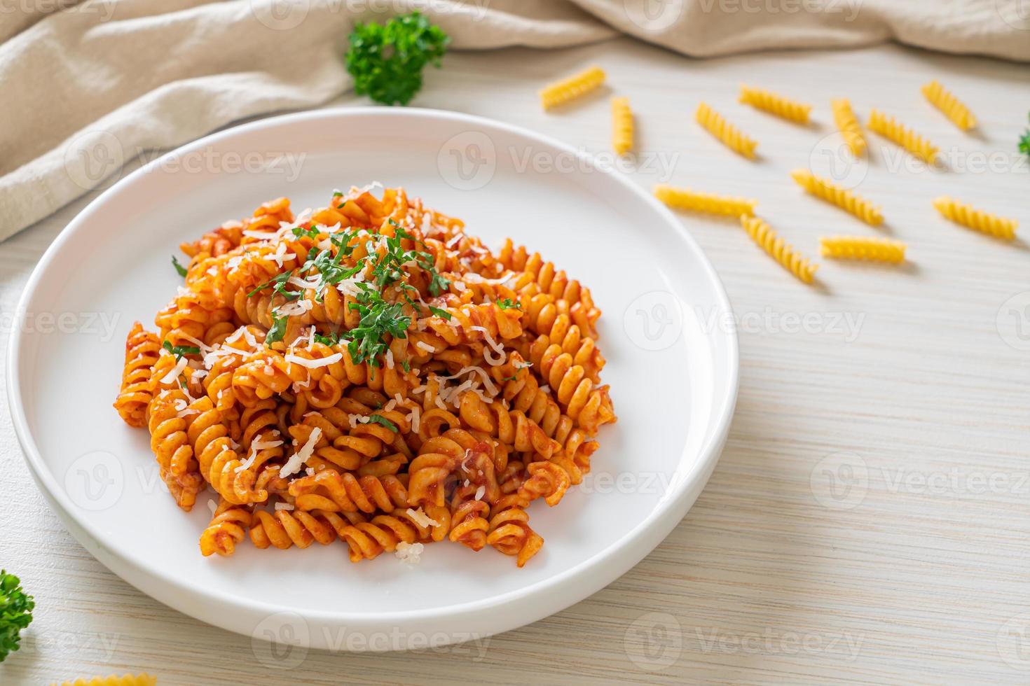 pasta a spirale o spirali con salsa di pomodoro e salsiccia - stile italiano foto