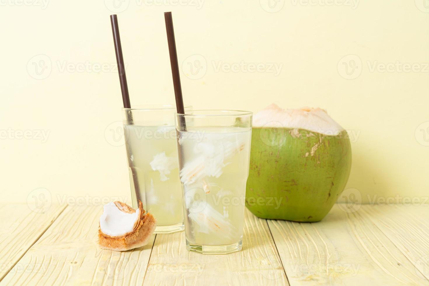 acqua di cocco o succo di cocco in bicchiere con cubetto di ghiaccio foto