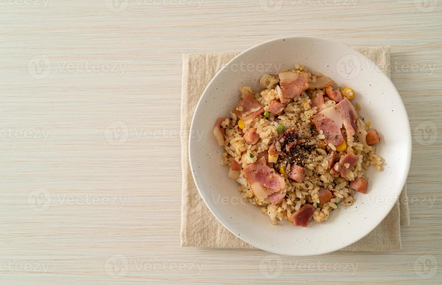 riso saltato con pancetta prosciutto cotto e ciotola di peperoni neri foto