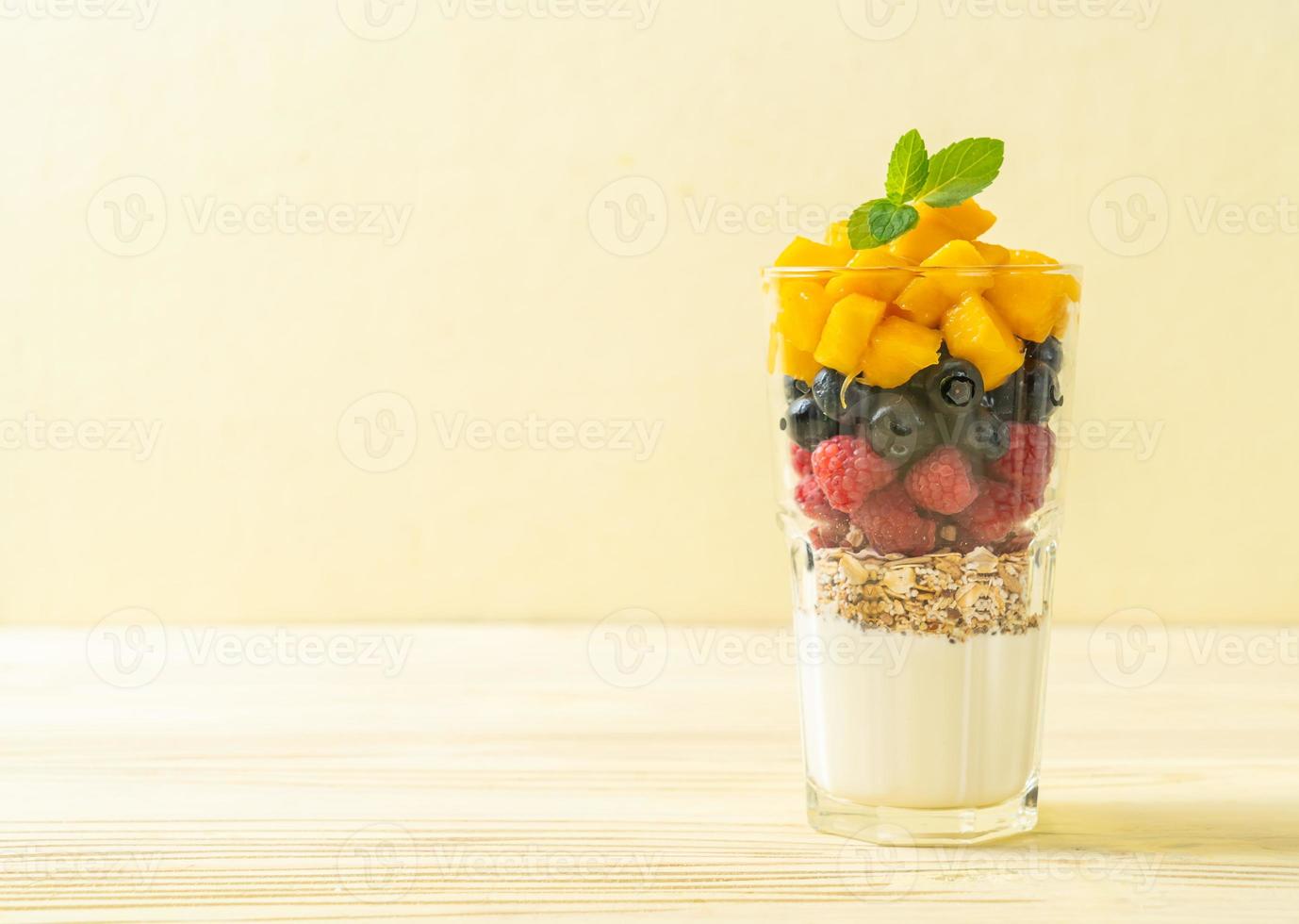 mango, lampone e mirtillo fatti in casa con yogurt e muesli - stile di cibo sano foto