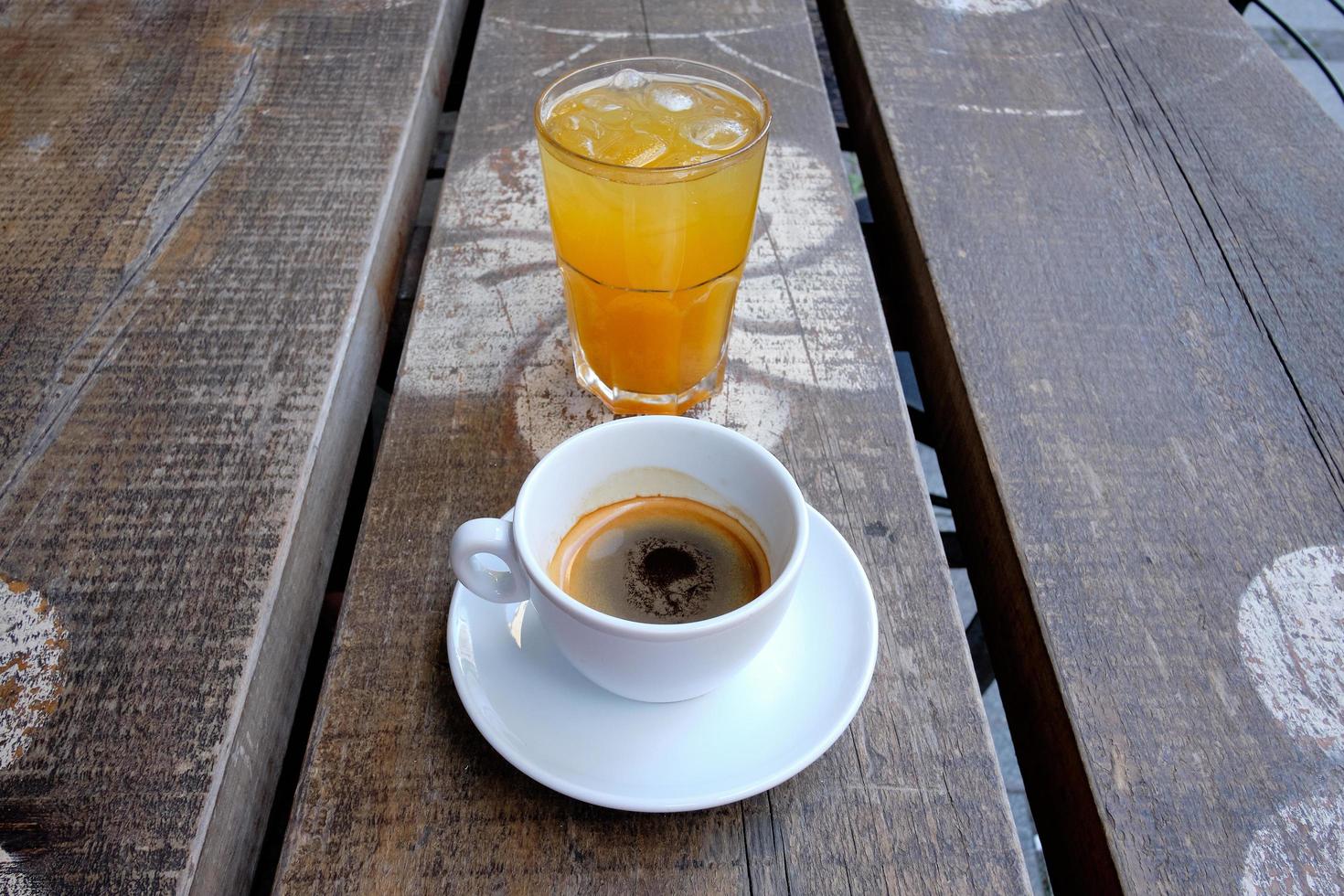 tazza di caffè e un bicchiere di succo d'arancia fresco su una tavola di legno foto