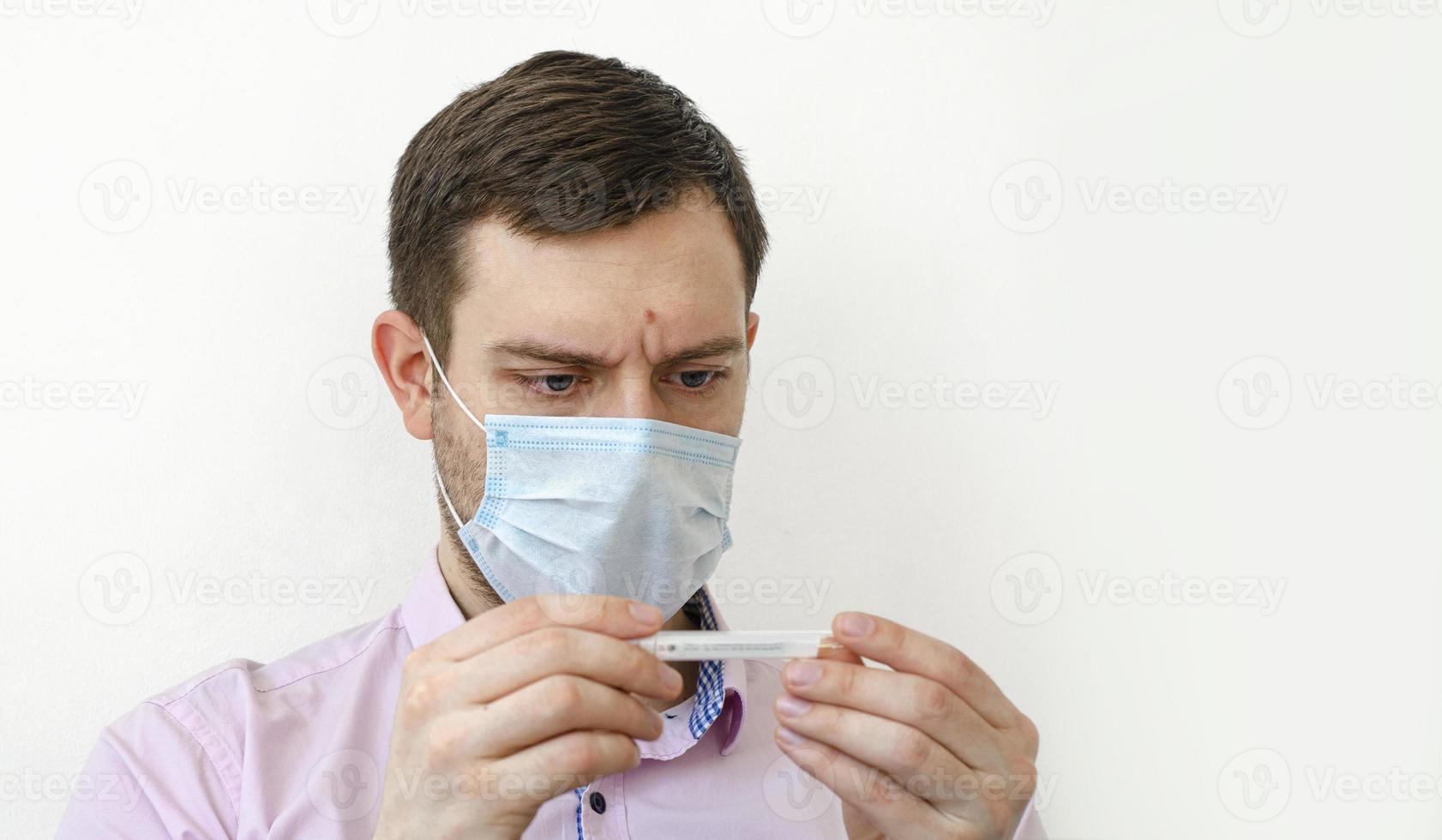 un uomo in camicia misura la temperatura. alta temperatura. foto