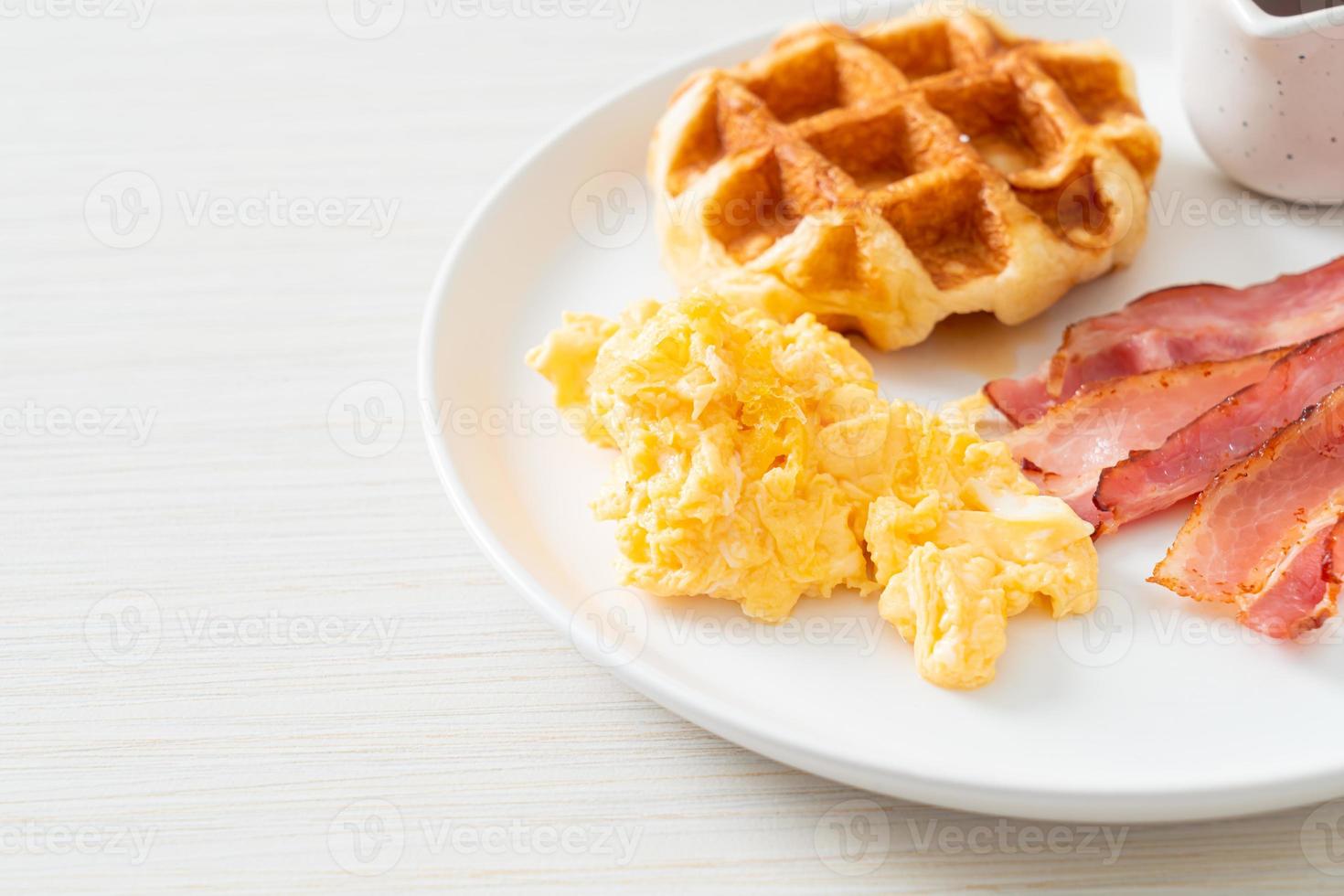 uova strapazzate con bacon e waffle a colazione foto