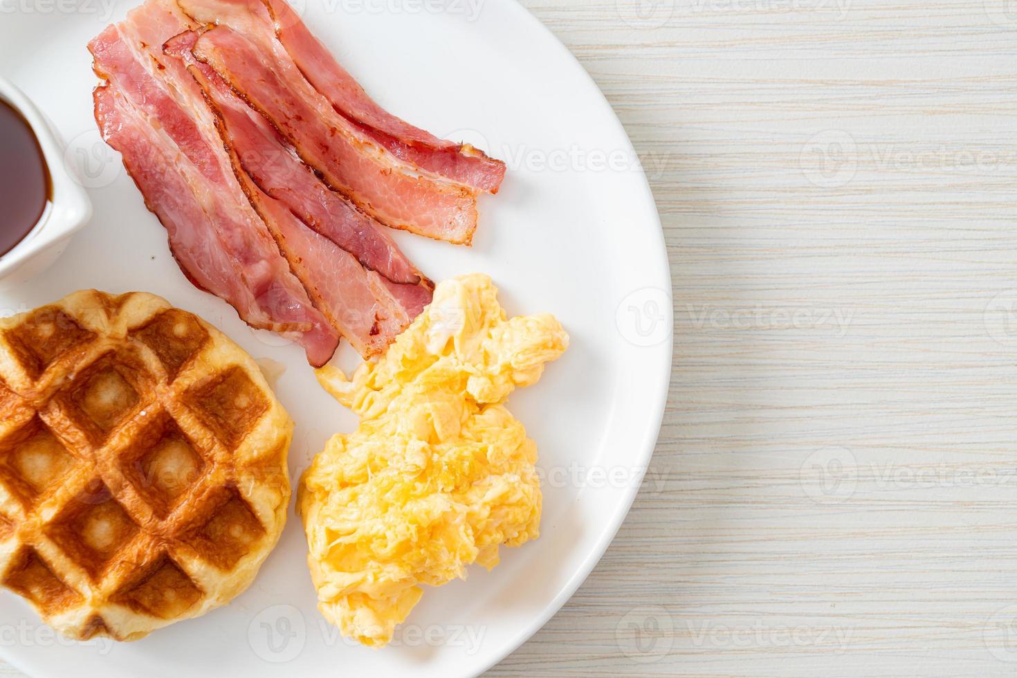 uova strapazzate con bacon e waffle a colazione foto