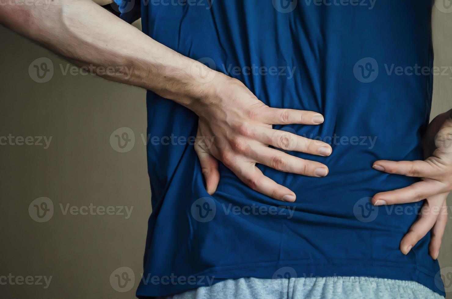 un uomo che si tiene le spalle. mal di schiena. foto