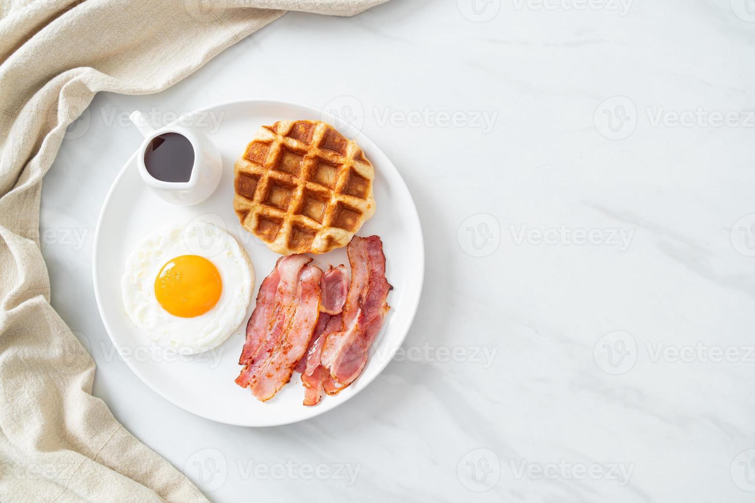 uovo fritto con bacon e waffle per colazione foto