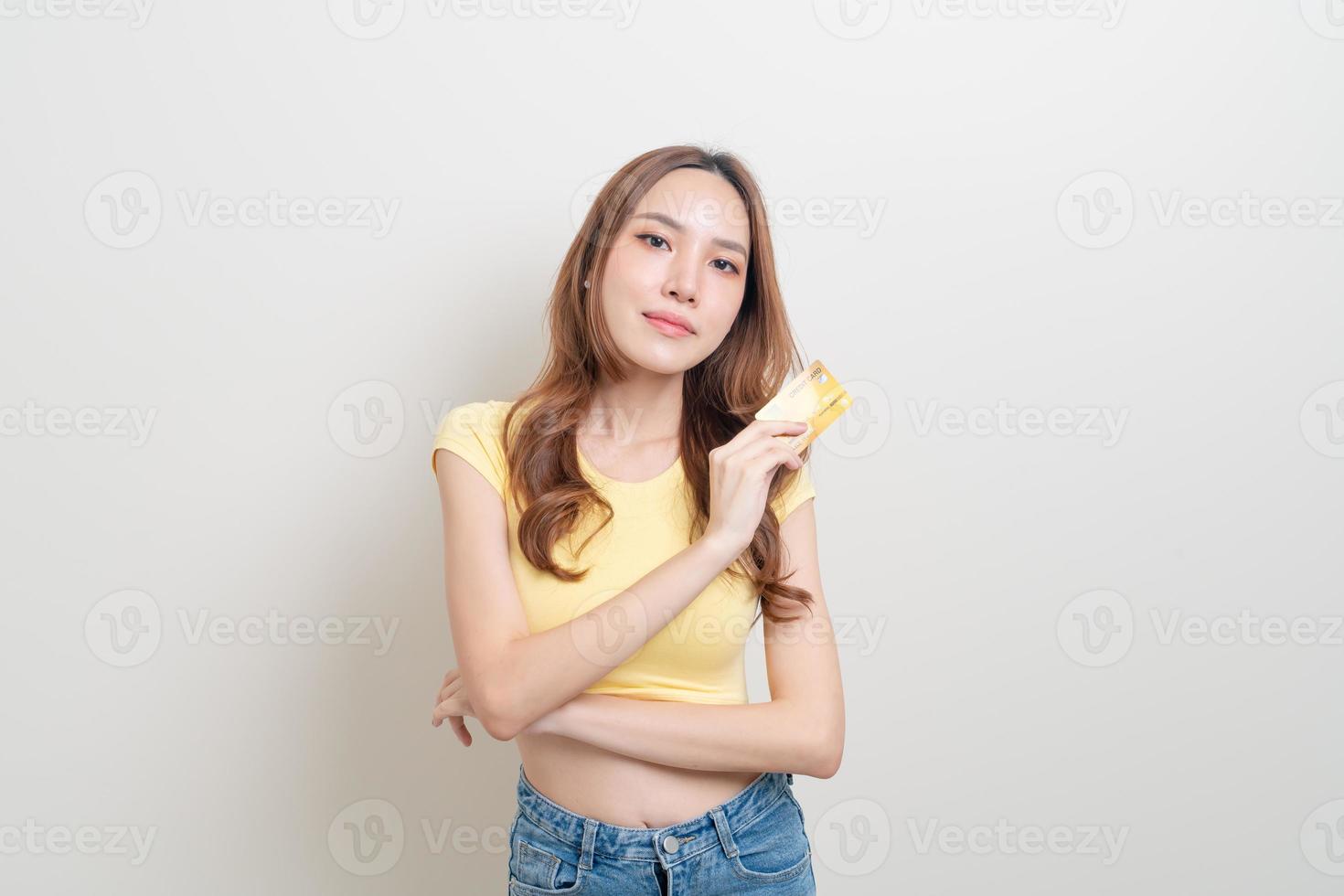 ritratto bella donna asiatica in possesso di carta di credito su sfondo bianco foto