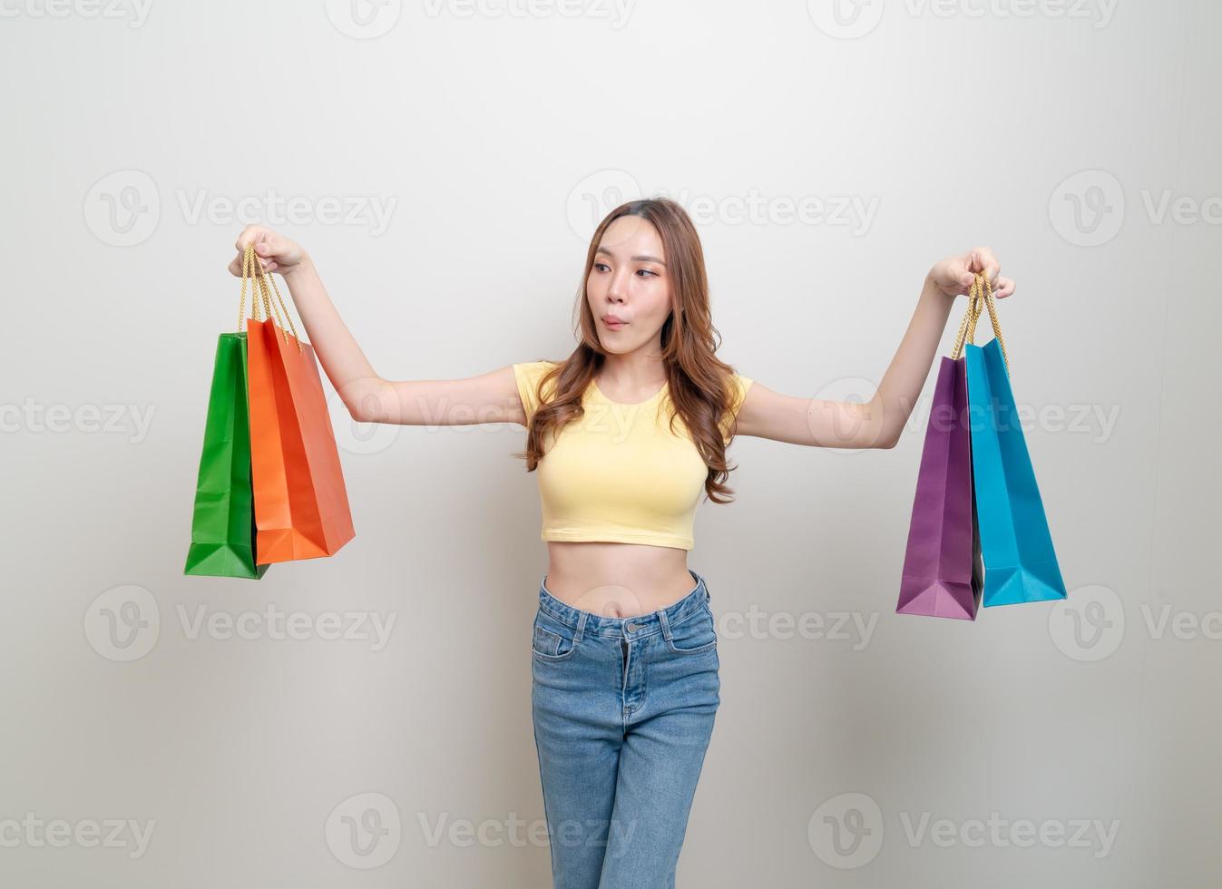 ritratto bella donna asiatica che tiene la borsa della spesa su sfondo bianco foto