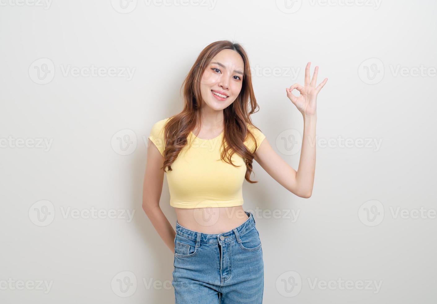 ritratto bella donna asiatica con mano mostra ok o d'accordo segno con la mano su sfondo bianco foto