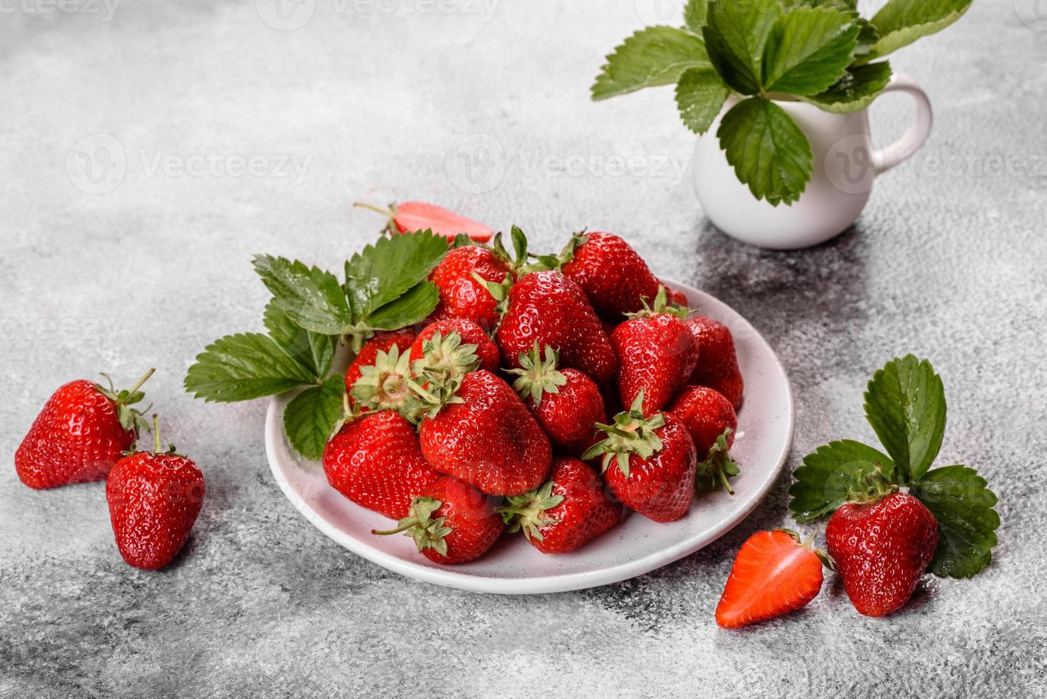 belle fragole fresche e succose sulla superficie del cemento foto