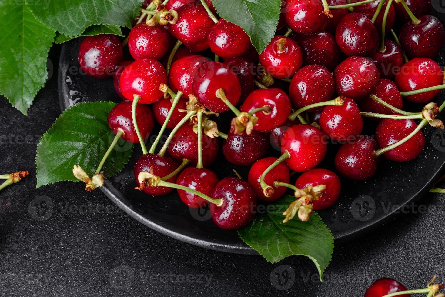 bacche fresche e deliziose di ciliegie rosse brillanti strappate nel giardino estivo foto