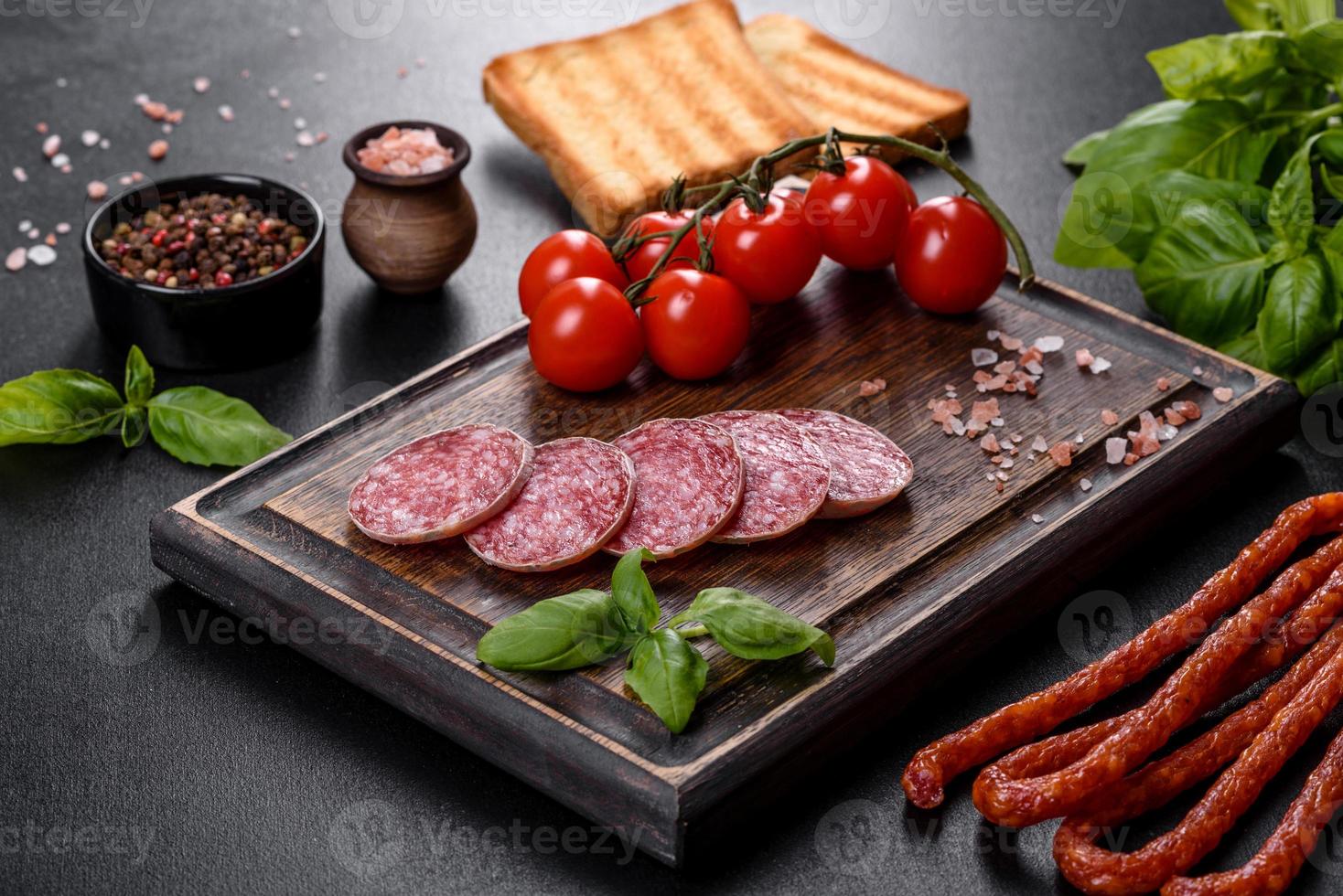 salame di salsiccia secca spagnola su fondo di cemento scuro foto