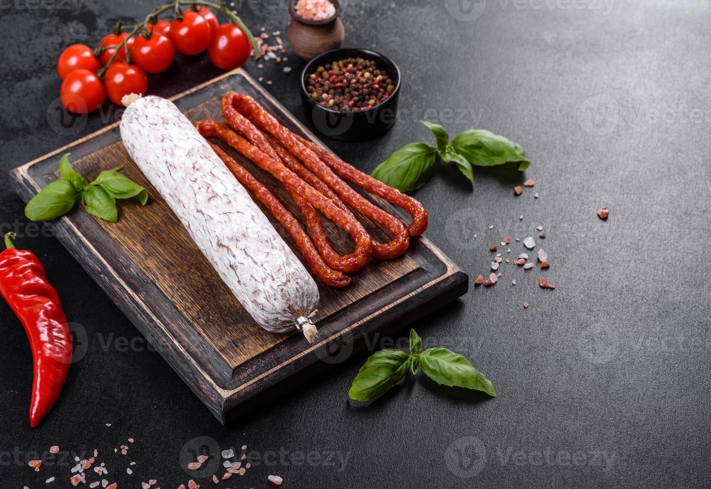 salame di salsiccia secca spagnola su fondo di cemento scuro foto