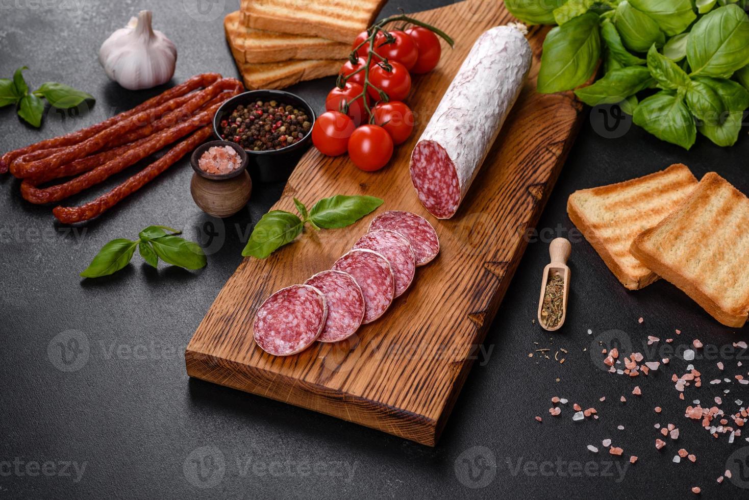 salame di salsiccia secca spagnola su fondo di cemento scuro foto