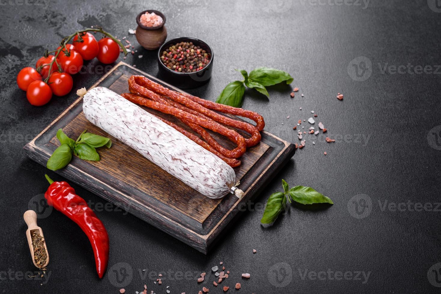 salame di salsiccia secca spagnola su fondo di cemento scuro foto