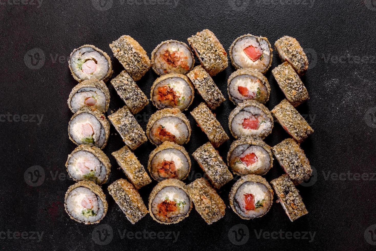 rotoli di sushi freschi e deliziosi su uno sfondo scuro foto