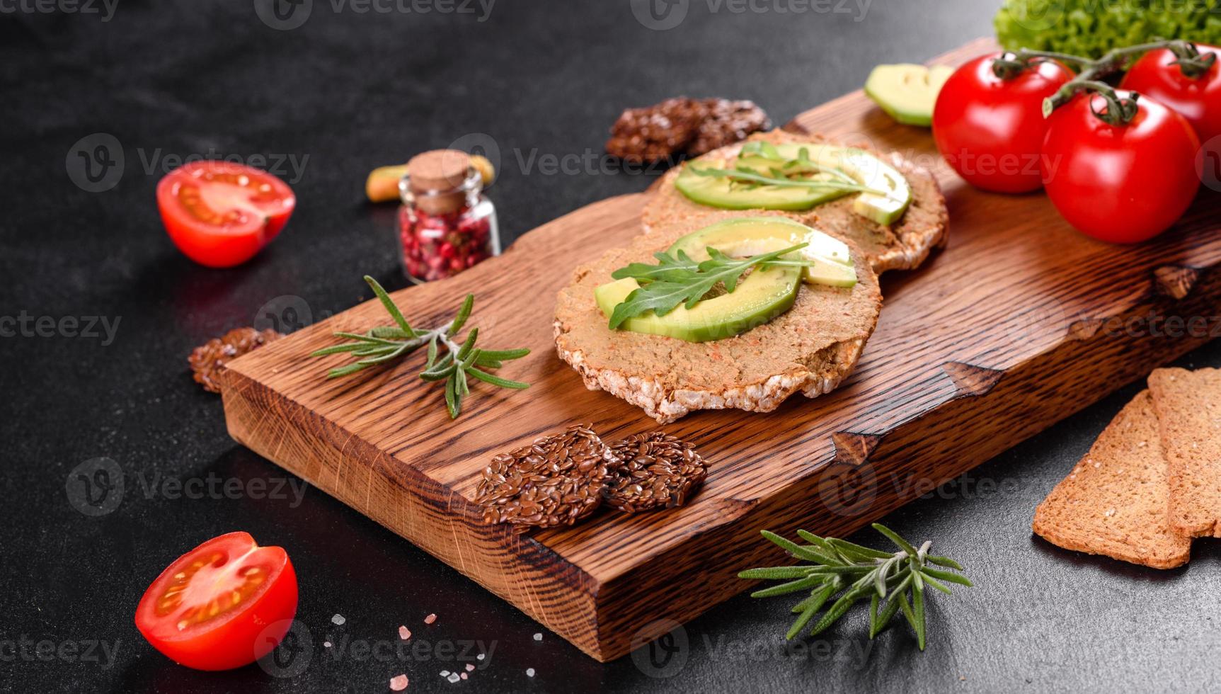 gustoso panino fresco con pasta di fegato, pezzi di avocado e rucola foto