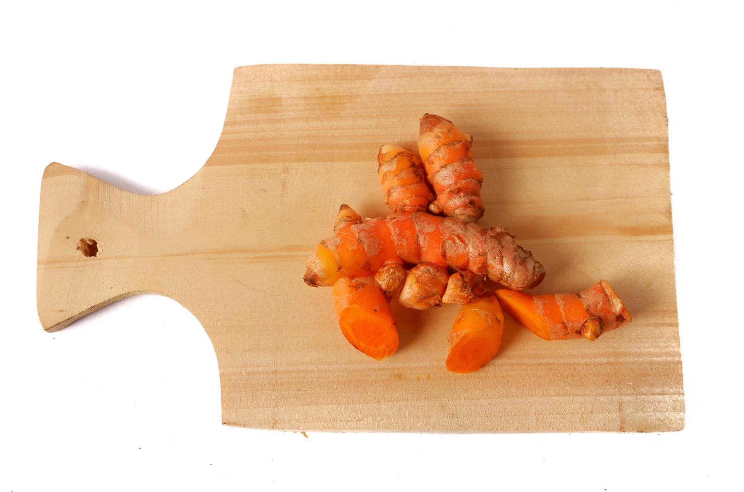 curcuma su un tagliere di legno isolato su sfondo bianco foto