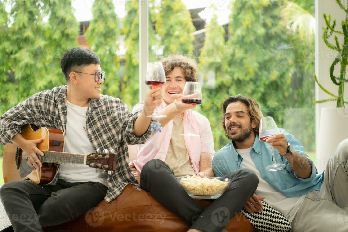 multietnico gruppo di amici avendo divertimento giocando chitarra e cantando insieme a casa foto