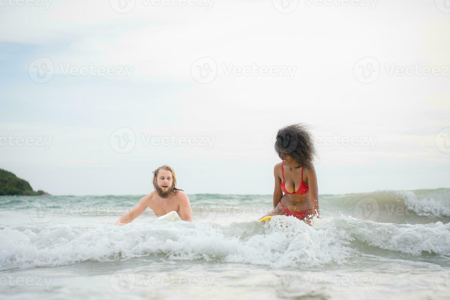 giovane uomo e donna avendo divertimento con tavola da surf nel il oceano su un' soleggiato giorno foto