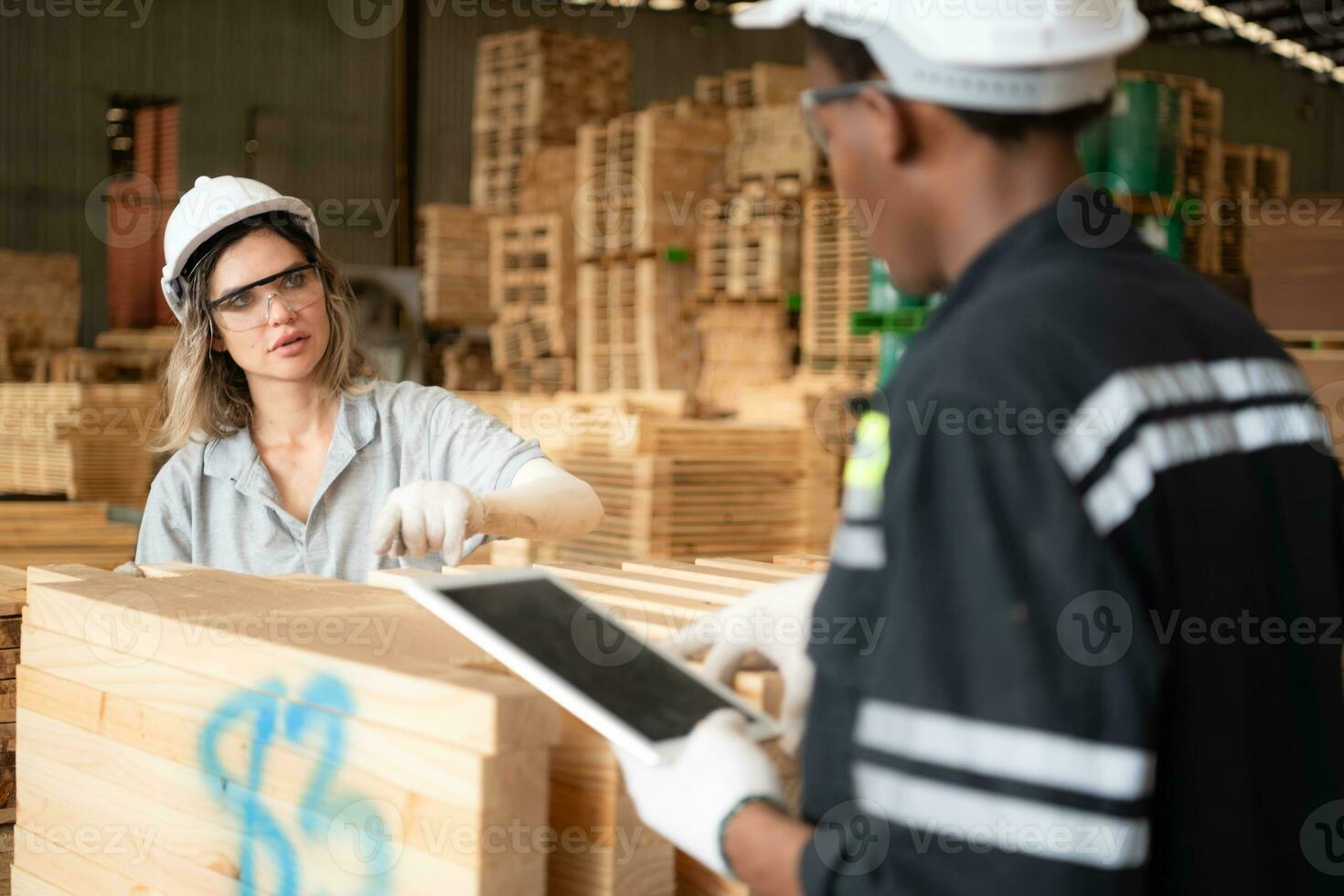 giovane femmina e maschio magazzino lavoratori utilizzando digitale tavoletta per Lavorando nel di legno fabbrica, controllo il pulizia di il tavole foto