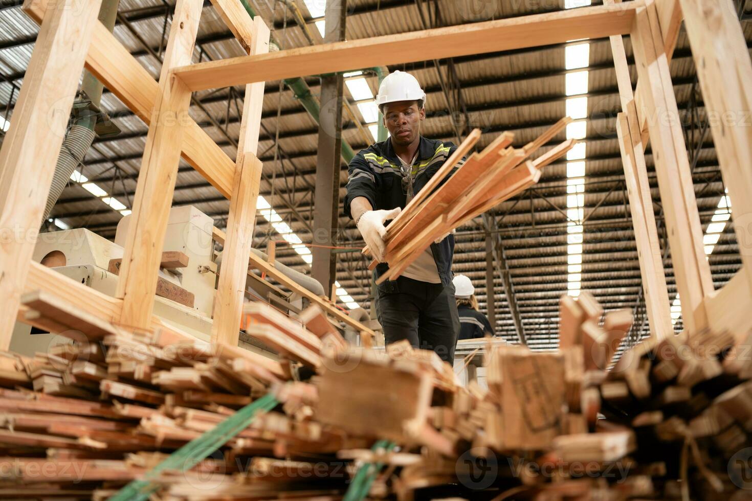 un' falegname lavori nel un' di legno fabbrica, raccogliere legna quello ha passato attraverso il legna fresa in piccolo pezzi. per essere inviato per essere formato in di legno pallet foto