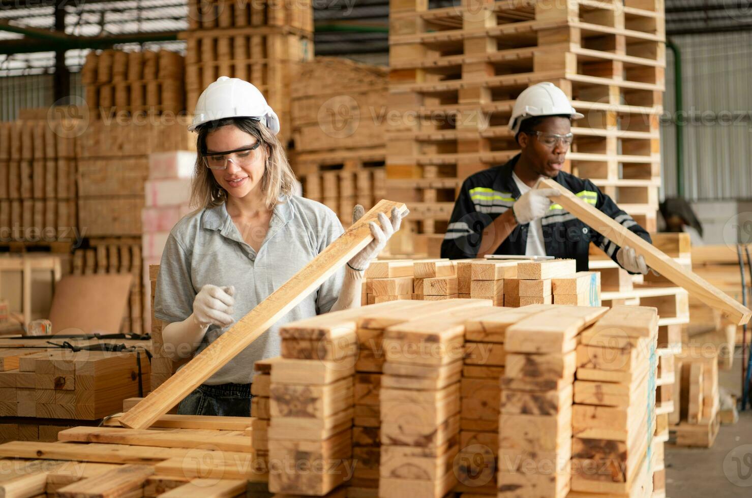 giovane femmina e maschio magazzino lavoratori utilizzando digitale tavoletta per Lavorando nel di legno fabbrica, controllo il pulizia di il tavole foto