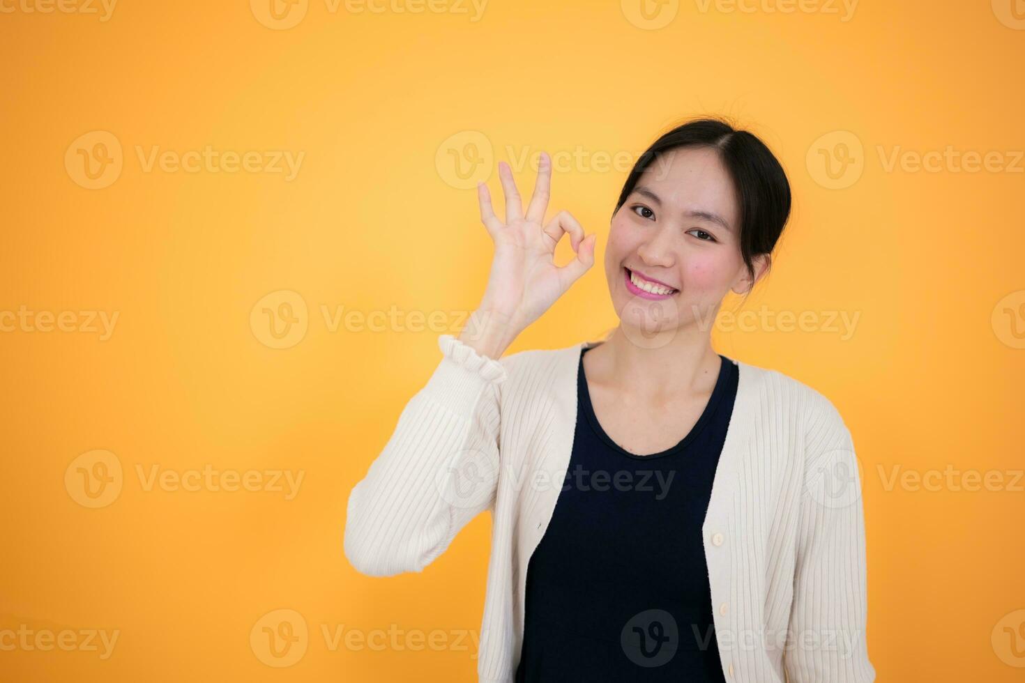 ritratto di un' contento giovane asiatico donna isolato su giallo sfondo foto