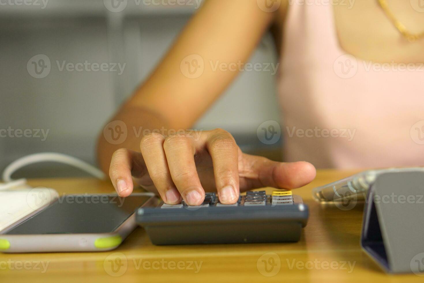 asiatico donne stampa per opera a partire dal casa clic su il calcolatrice per vedere profitti. foto