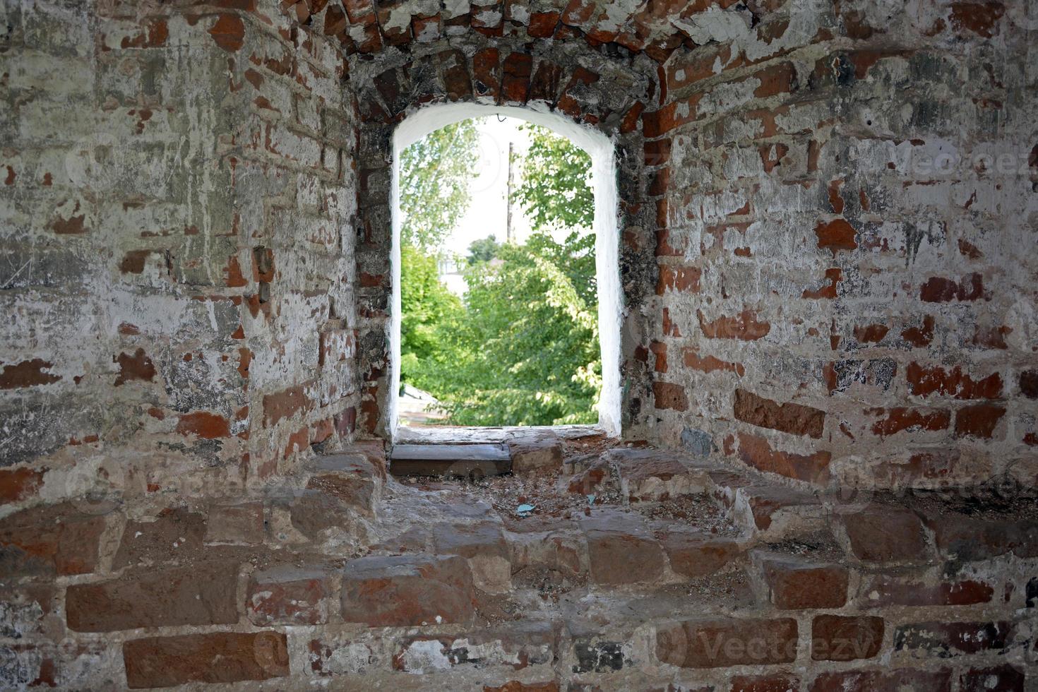 una finestra in un edificio in pietra crollato foto