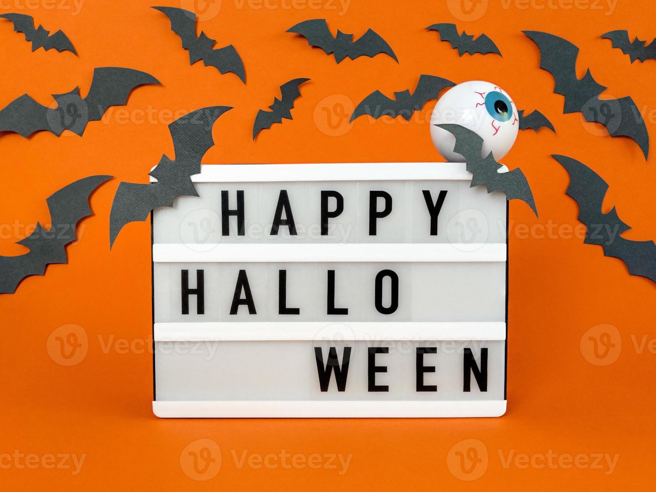 scatola luminosa con frase di halloween felice con pipistrelli e decorazione del bulbo oculare foto