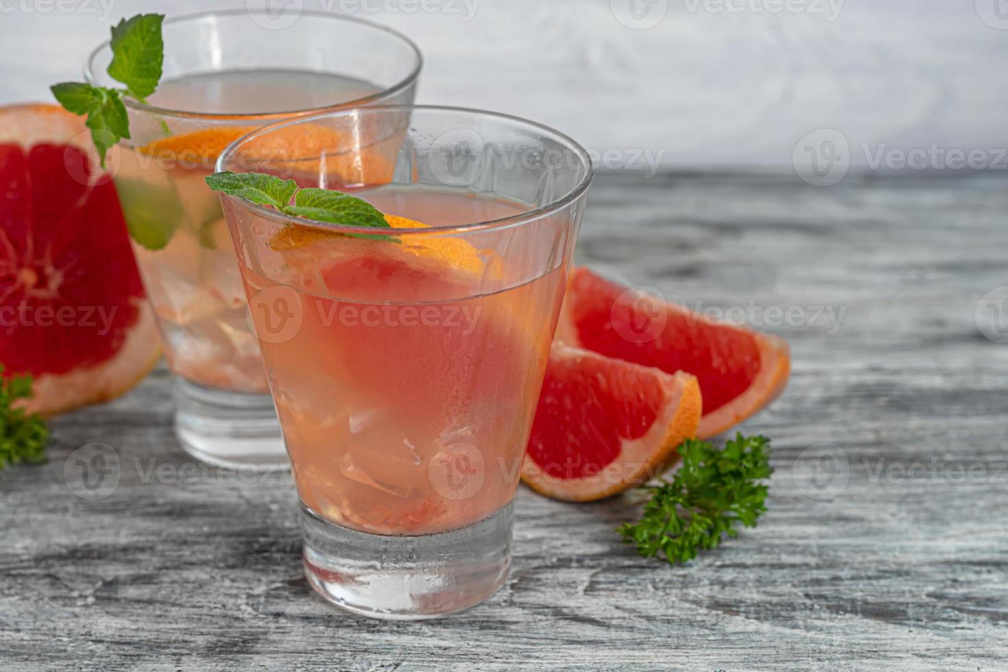 cocktail al pompelmo su fondo chiaro con un rametto di menta foto