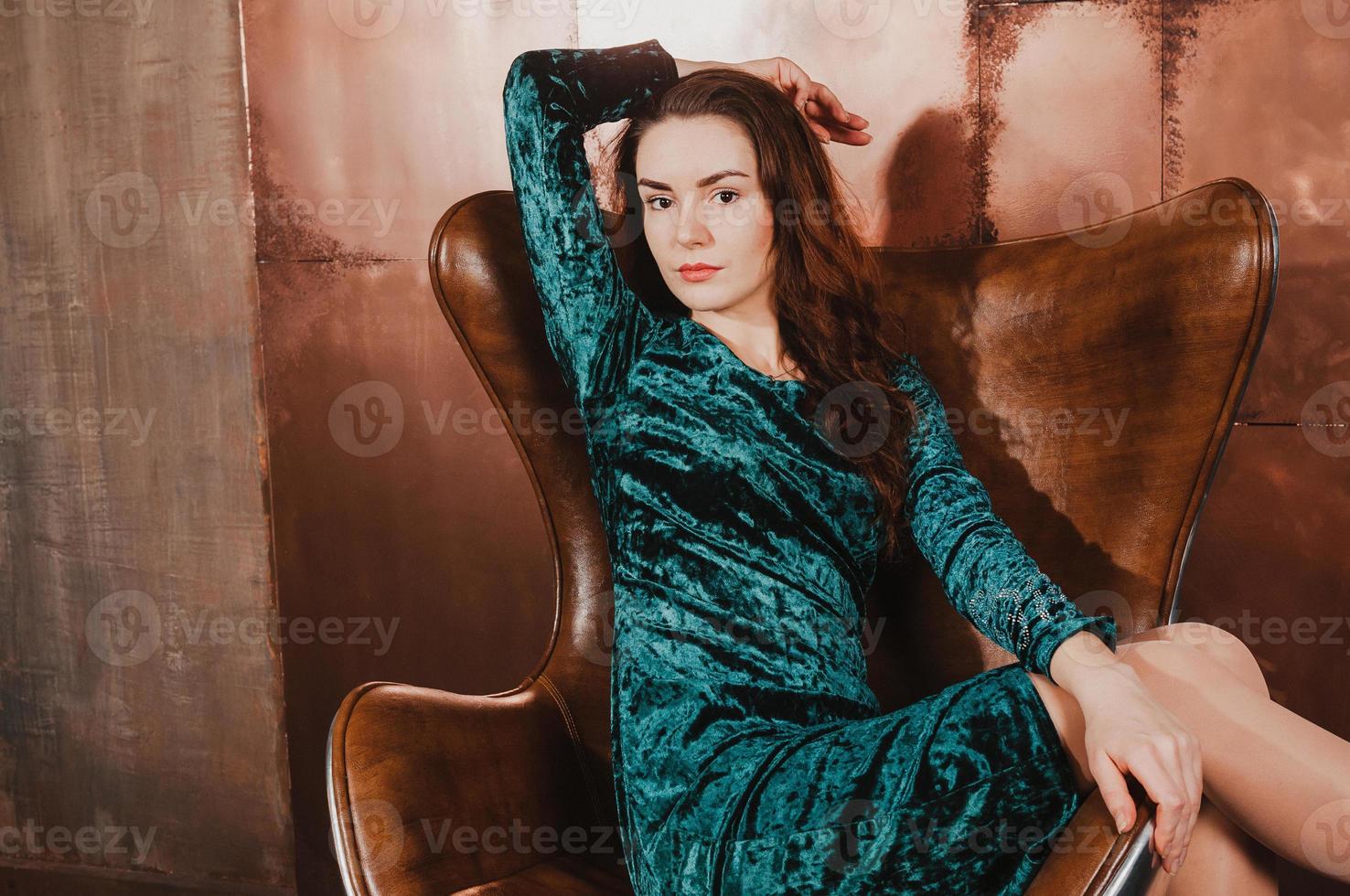bella giovane donna su una sedia marrone in pelle foto