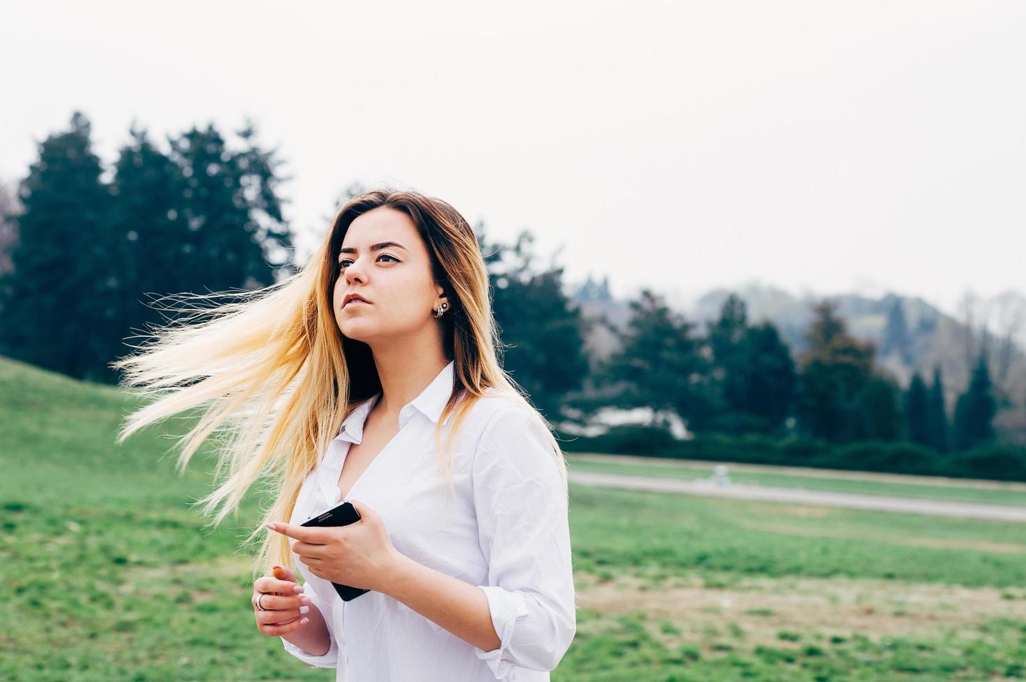 bella giovane donna dai capelli lunghi nel parco ventoso foto