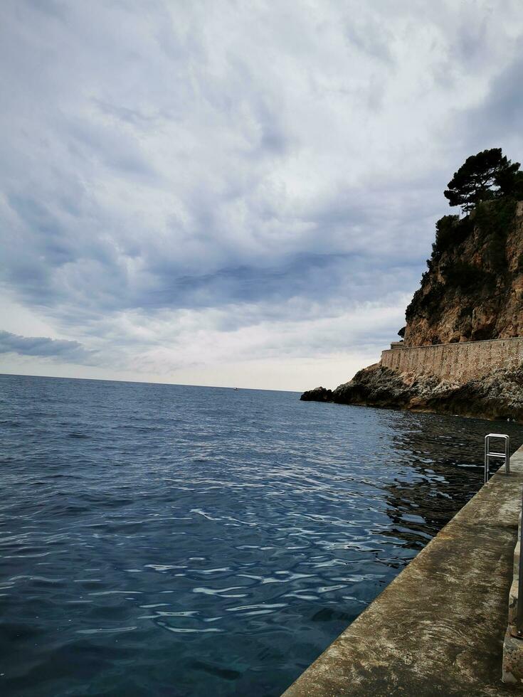 foto di un' sereno panchina prospiciente il vasto oceano su un' tranquillo, calmo molo