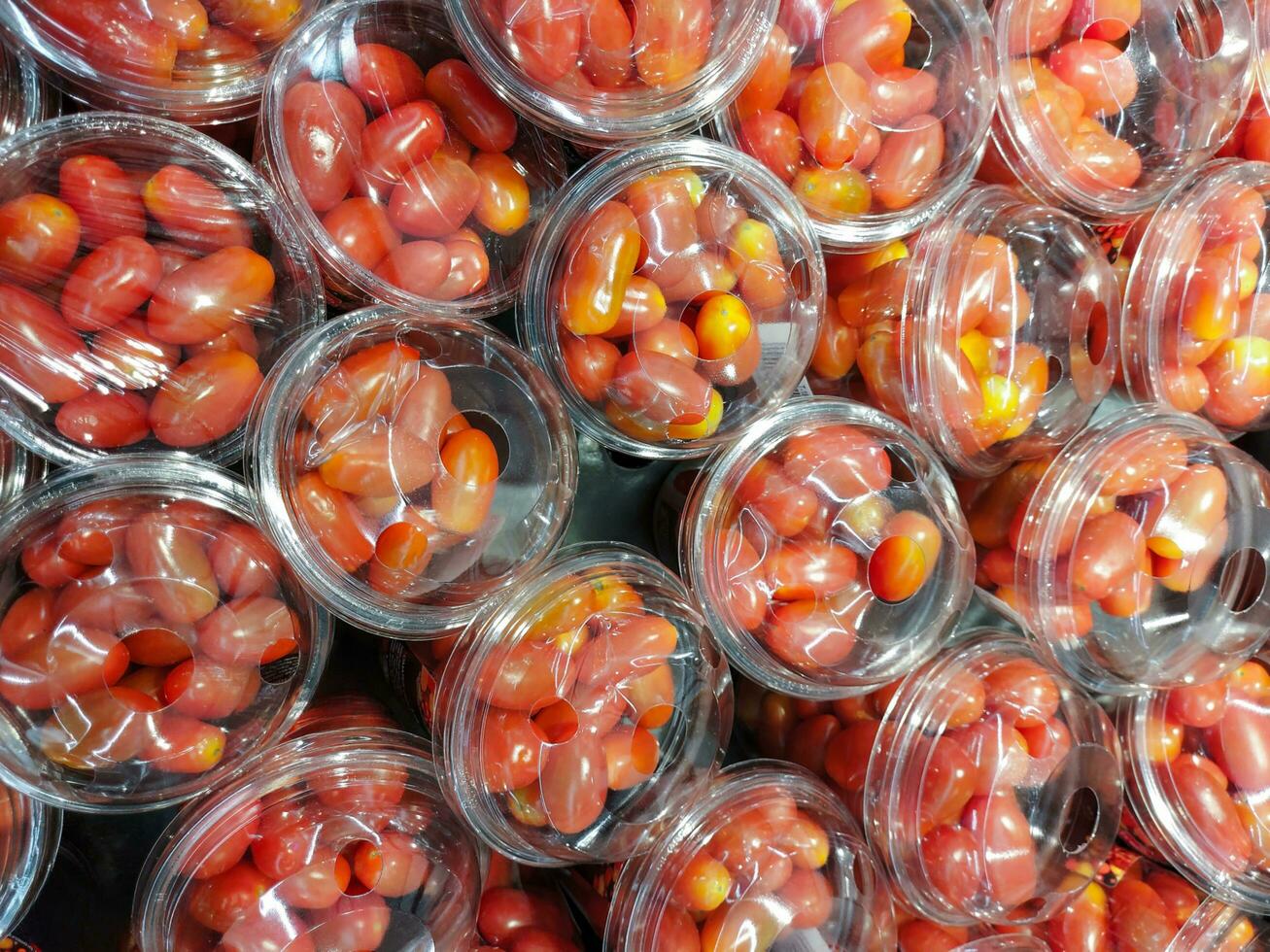 fresco pomodori confezionato nel plastica bicchieri pronto per mangiare, fresco maturo pomodori su contatore a vendita all'ingrosso mercato, il imballaggio è rosso pomodori a partire dal biologico fram.cherry pomodori raccogliere nel separato plastica scatola foto