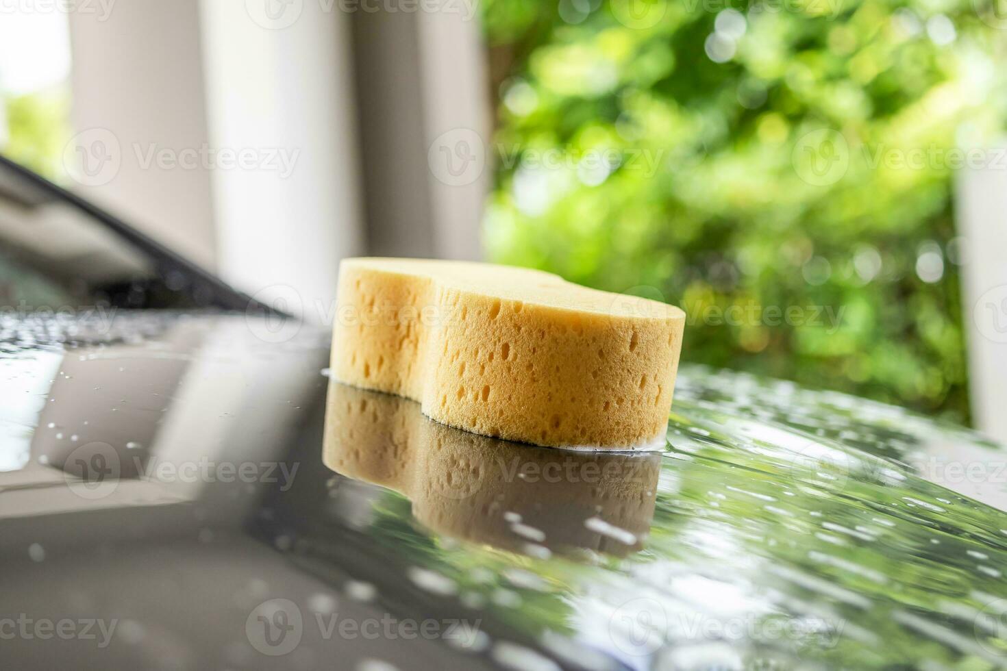 auto pulizia e lavaggio con giallo spugna e schiuma sapone foto