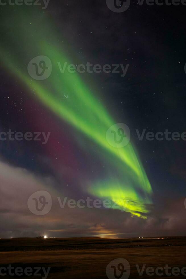 durante orario invernale, famoso settentrionale luci macchiato al di sopra di colline coperto con neve. islandese magico aurora Borealis creare incredibile mostrare quello Brighten su freddo notte cielo con stelle. foto