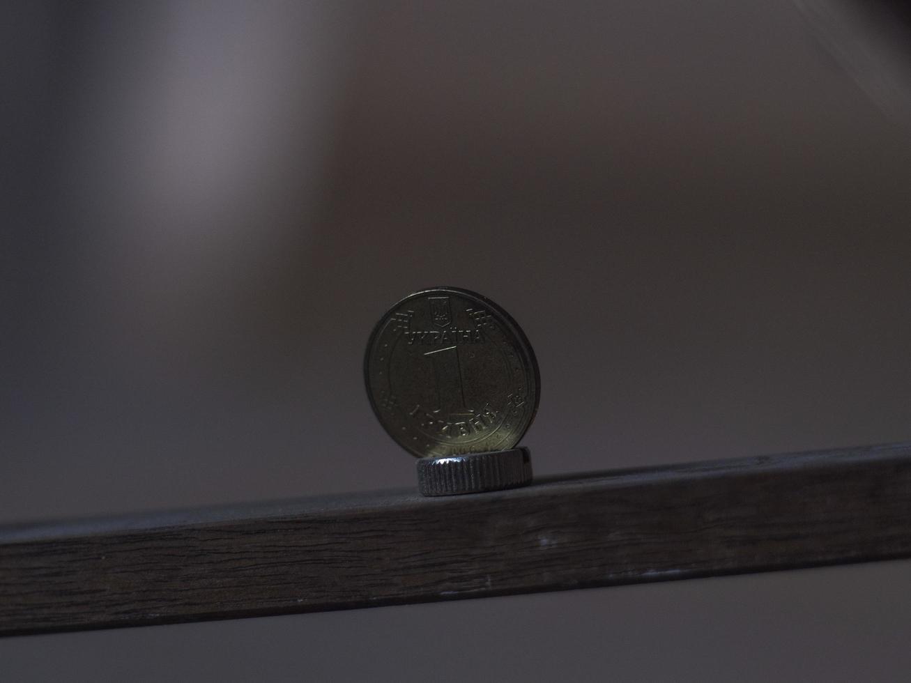 moneta ucraina metallica su un asse di legno. moneta grivna ucraina foto