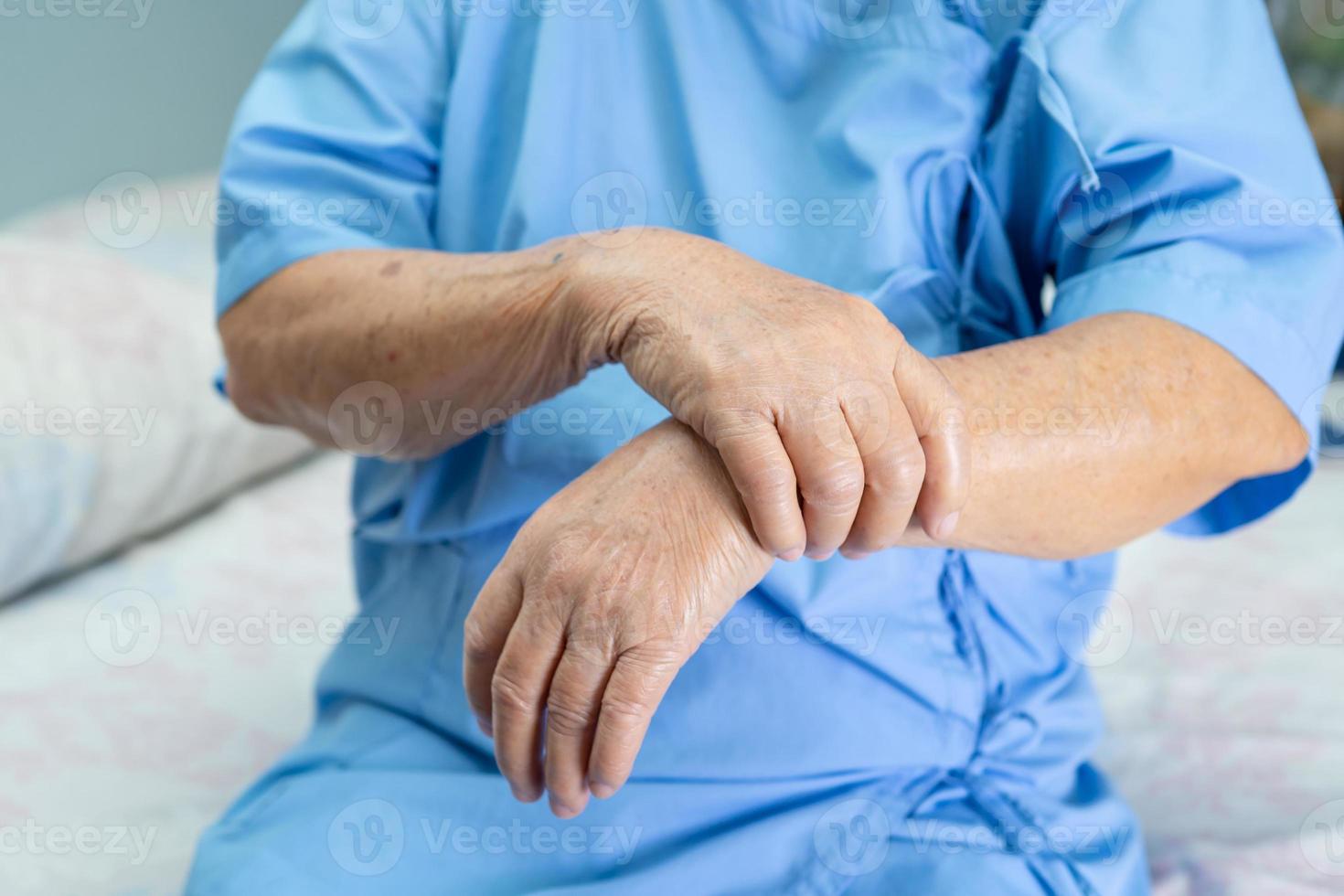 donna anziana asiatica paziente sente dolore al polso e al braccio foto