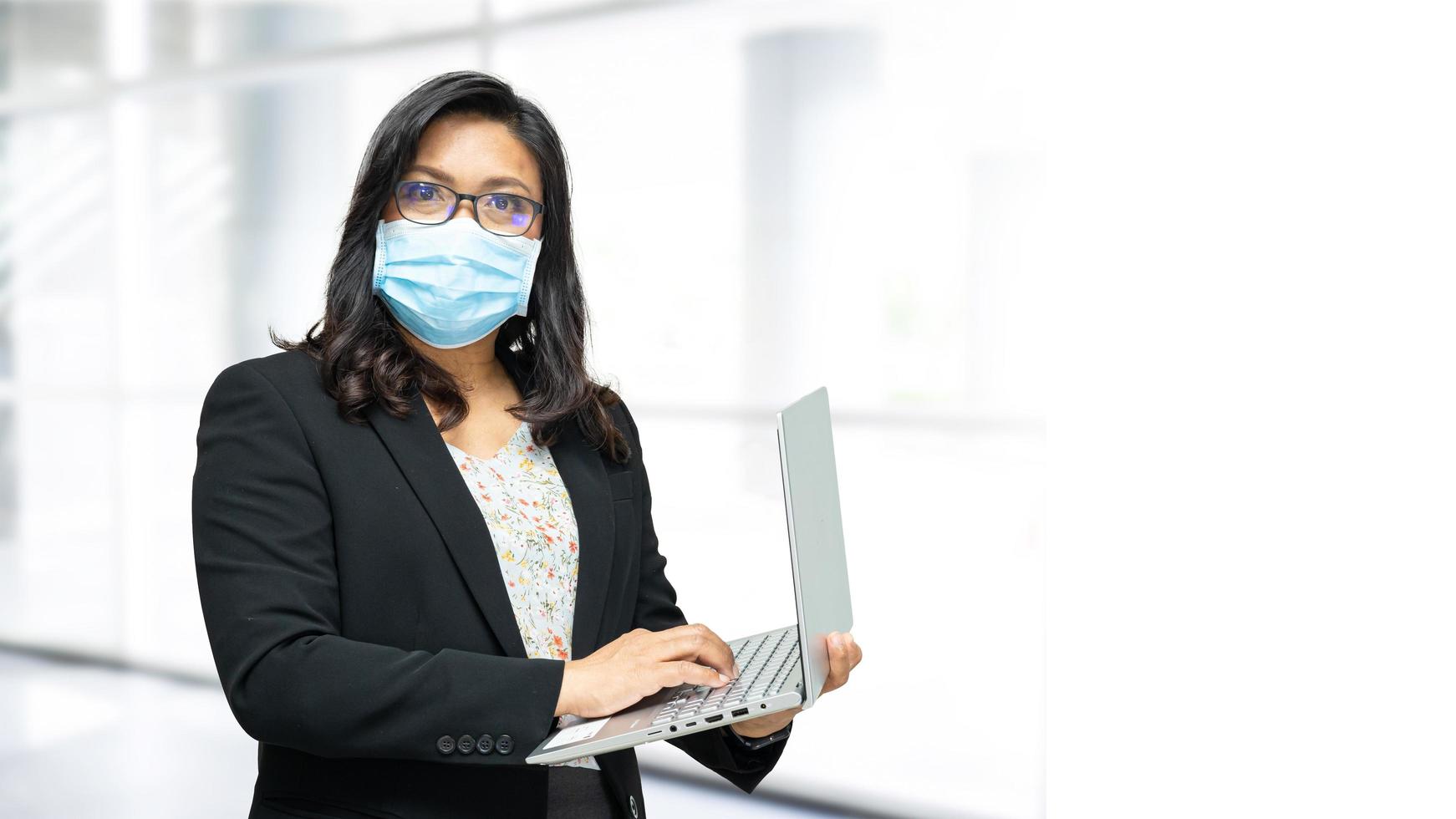 signora asiatica che indossa una maschera in ufficio per proteggere il coronavirus. foto