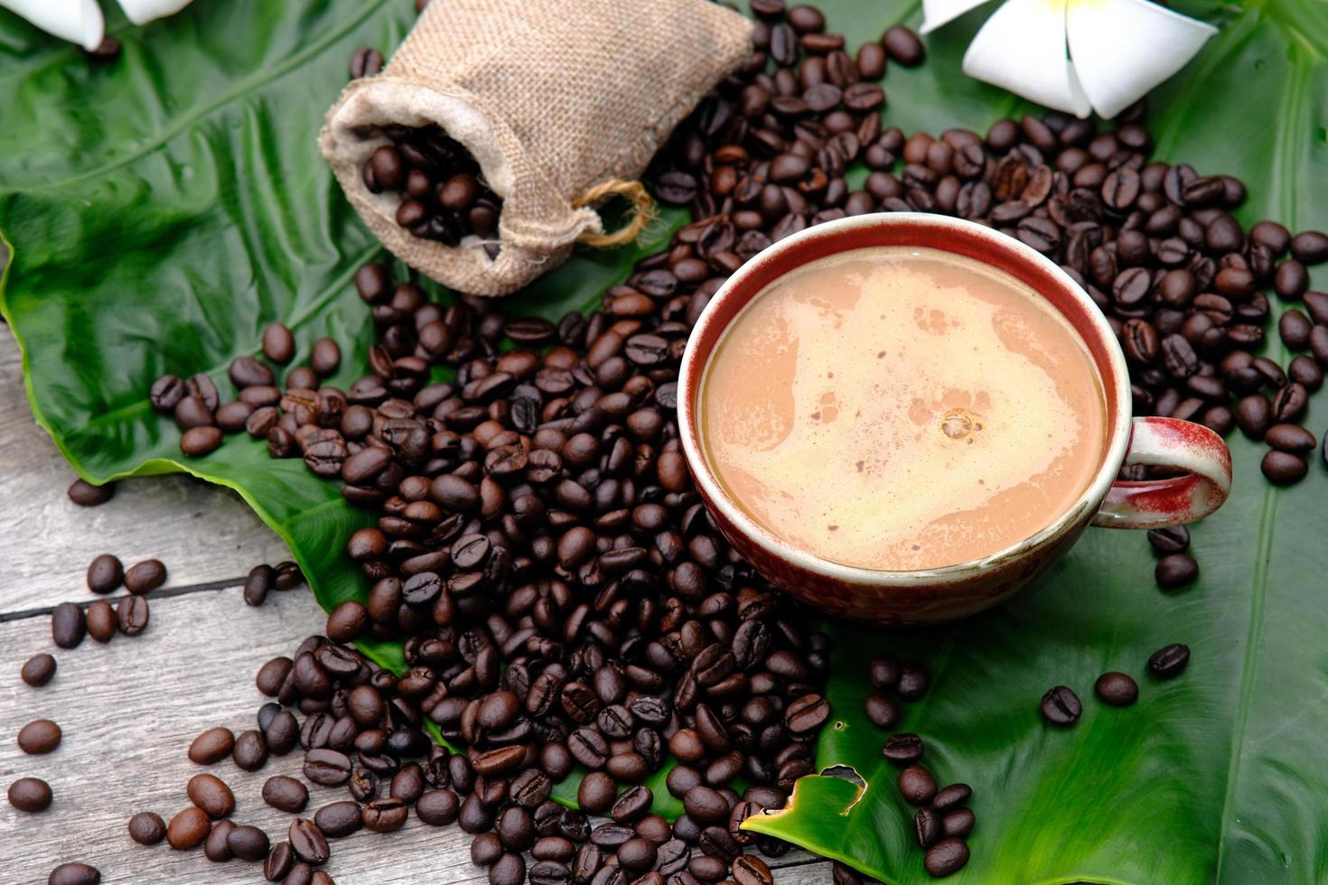 tazza di caffè con chicchi di caffè sul tavolo di legno foto