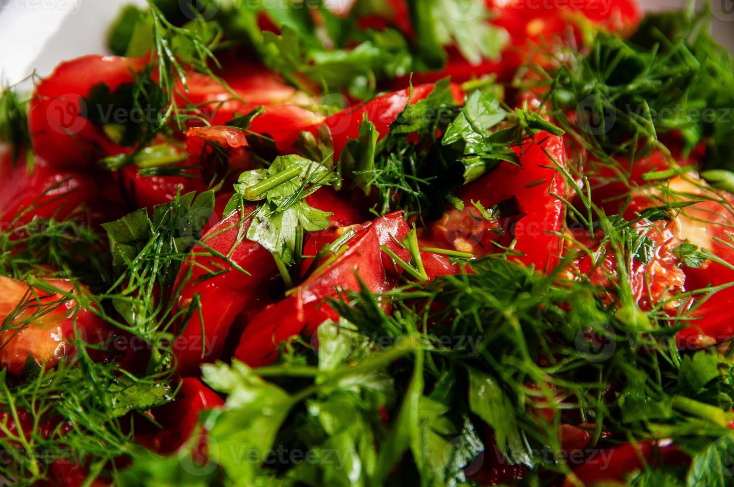 Insalata di pomodoro prezzemolo e aneto su un piatto bianco foto