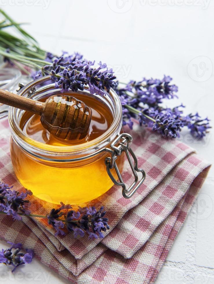 vasetto con miele e fiori di lavanda fresca foto