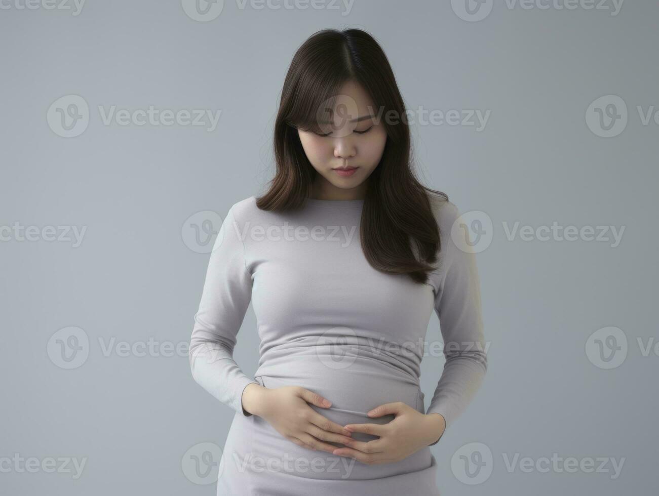 asiatico donna appare per essere nel dolore su grigio sfondo ai generativo foto