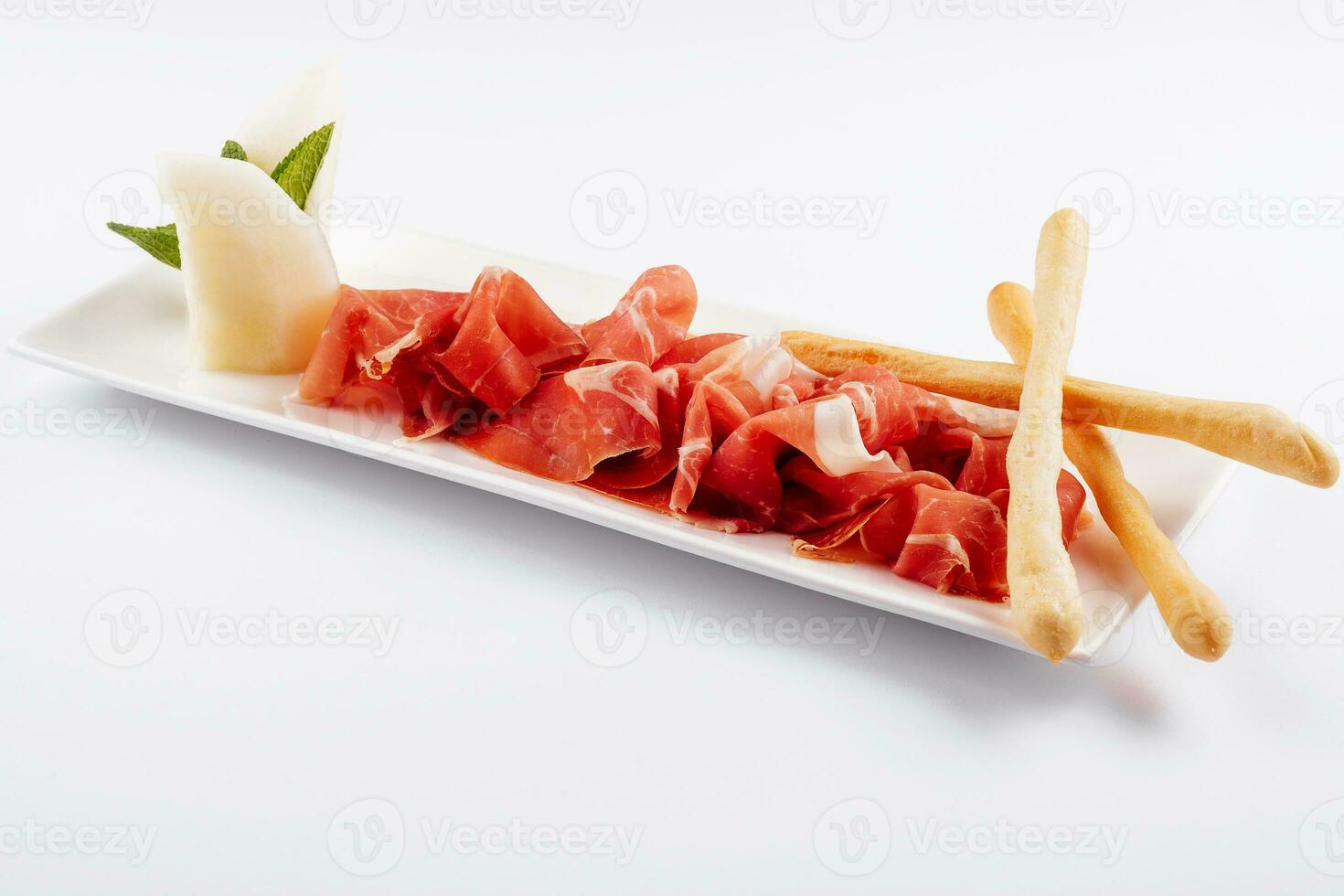 jamon Serrano, prosciutto crudo o parma prosciutto e grissini su bianca piatto foto