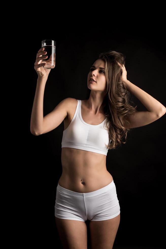 modello di fitness femminile che tiene un bicchiere d'acqua foto