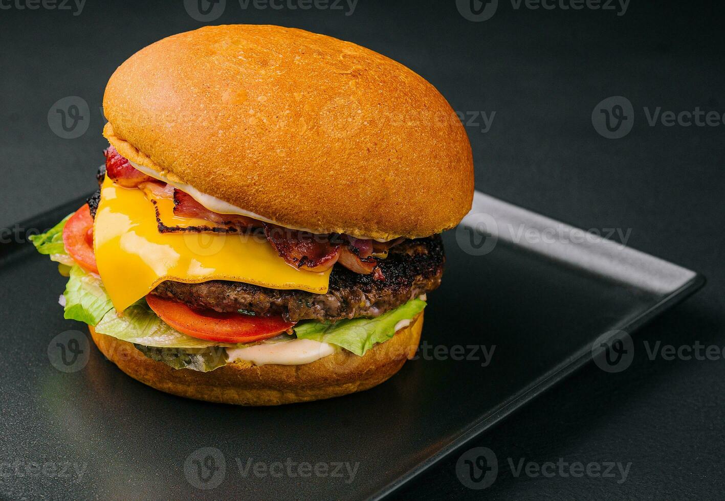 vicino su alto gustoso hamburger con formaggio servito su vassoio foto