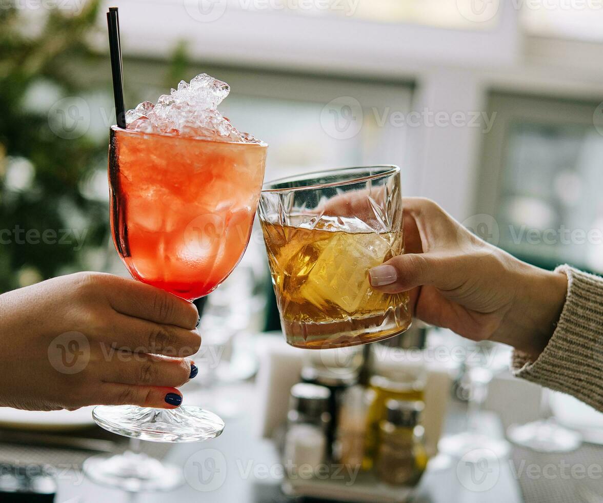 amici tostatura con bicchieri di whisky e fragola cocktail foto