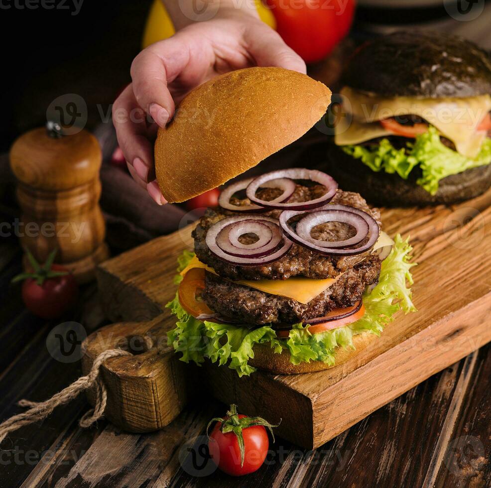 vicino su Visualizza di femmina cucinando fresco gustoso hamburger foto